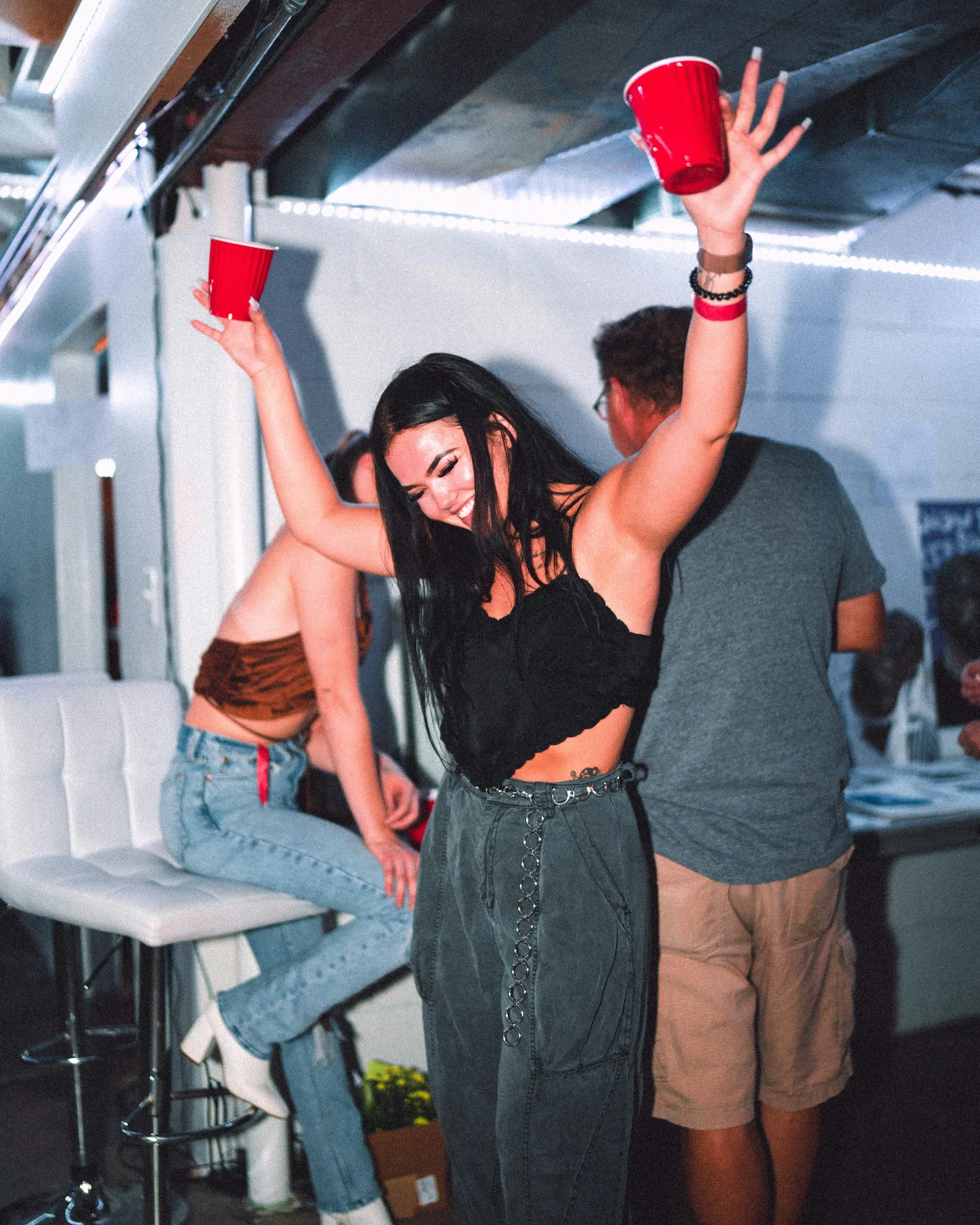 Friends dancing and raising cups at an event